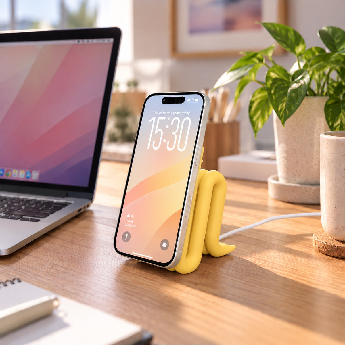 MagSafe iPhone Stand in Yellow holding an iPhone on a desk
